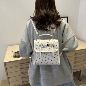 Cute white leather polka dot backpack featuring an embroidered dog with a party hat
