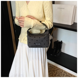 Detail of grey denim boston bag with black polka dots and rich rabbit label