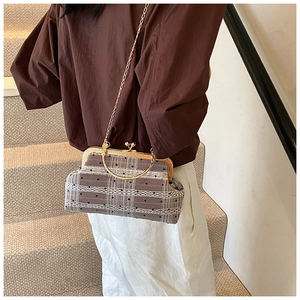 Detail of retro shell bag featuring bamboo pattern metal handles and lace polka dot fabric