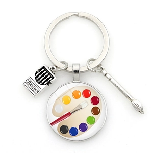 Artistic silver metal keychain featuring miniature paintbrush and colorful palette charms