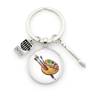 Detailed shot of artist keychain with mini paint brushes and crayons box charms