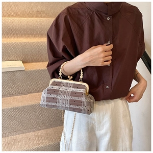 Detailed view of retro plaid shell bag with bamboo handle and gold kiss-lock clasp