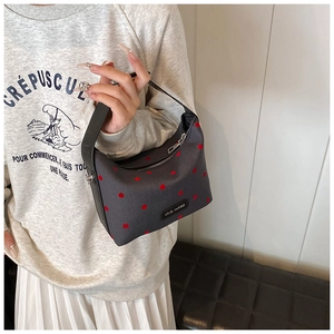 Detail of grey canvas tote bag with red polka dots and rich rabbit label on side