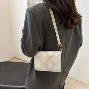 Minimalist beige quilted crossbody bag with adjustable strap and gold chain detail