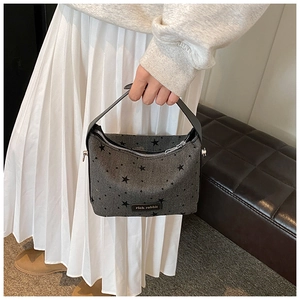 Detail of grey canvas tote bag with black star patterns and rich rabbit logo label