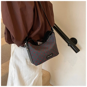 Detail of dark grey polka dot shoulder bag with rich rabbit leather tag and buckle