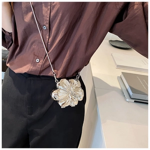 Close-up of silver flower clutch bag with metallic petals and delicate chain strap