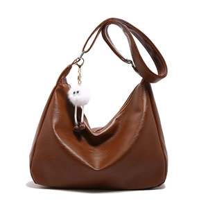 Braune Vintage-Hobo-Tasche aus Leder mit Litschi-Textur und flauschigem weißem Anhänger