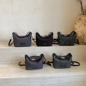 Mini crossbody pea bags with heart and star prints on elegant marble stairs