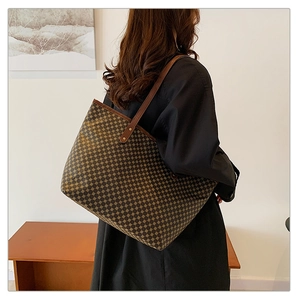 Close-up of a large geometric pattern tote bag with brown leather shoulder straps