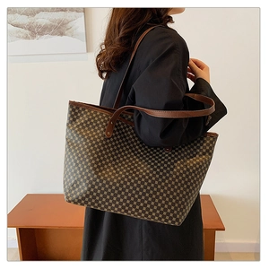 Detail of large tote bag featuring vintage geometric patterns and brown leather straps