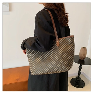 Detailed side view of a large tote bag with geometric pattern and brown leather straps