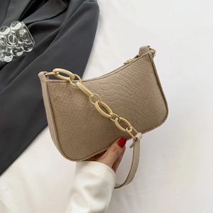 Beige faux crocodile skin baguette bag with stylish chain detail and shoulder strap