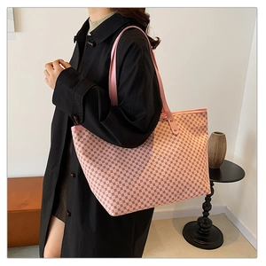 Detail of pink tote bag with geometric diamond pattern worn by a model in casual setting