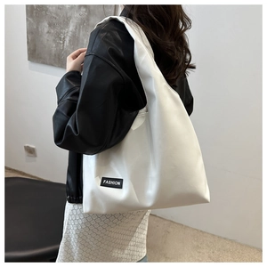 Model showing a large white PU leather tote bag with a black FASHION label on the side