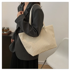 Macro view of geometric pattern tote bag with leather trim and dual handles