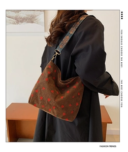 Detail of brown corduroy tote bag with red strawberry embroidery and ethnic style strap