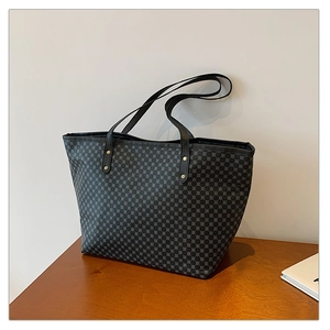 Macro detail of tote bag showing geometric grid pattern and metal rivet strap connector