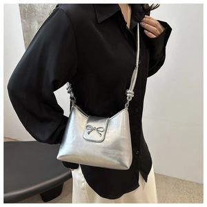 Détail du sac bandoulière argenté métallisé avec nœud décoratif et bandoulière nouée