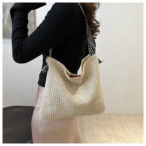 Detail der Stroh-Stofftasche mit kontrastierendem schwarz-weiß gestreiftem Schultergurt