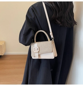 Chic beige square crossbody bag with glitter flap and metal buckle on casual model