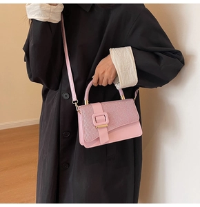 Pink leather handbag with glittery sequins and metal buckle styled on a model