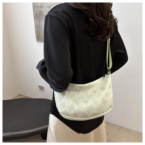 Detailed view of light green textured canvas hobo bag with adjustable shoulder strap