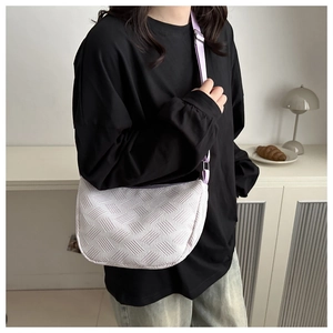 Lavender textured woven crossbody bag shown in a stylish home setting with lifestyle props