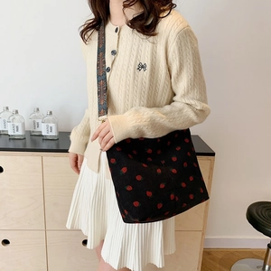 Black corduroy shoulder bag with strawberry print and colorful woven ethnic strap