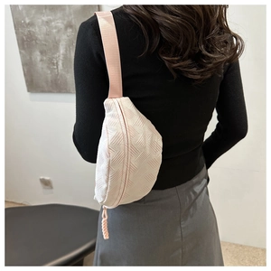 Detalle de la textura tejida geométrica del bolso rosa con correa ancha de nailon
