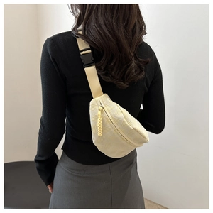 Detalle de bolso beige con textura geométrica tejida y correa ajustable de calidad