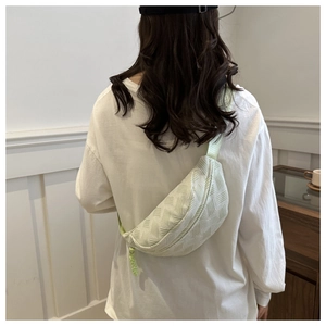 Detailed back view of a mint green crossbody chest bag with textured geometric pattern