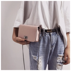 Detail of pink small square bag with silver twist lock and metal chain shoulder strap