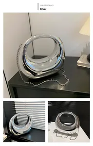 Détail du sac à main ovale argenté effet miroir avec sa fine bandoulière amovible