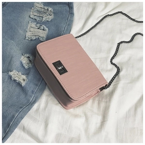 Macro view of pink pebble leather bag with chain strap and rectangular turn-lock