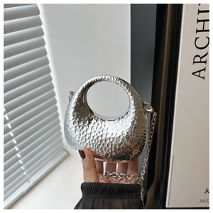 Silver crescent clutch with hammered metal texture and detachable chain strap