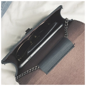 Detail view of the small square bag interior showing capacity for sunglasses and phone