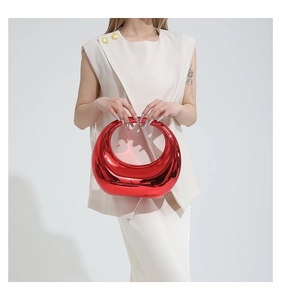 Détail du sac à main rouge métallisé avec un design semi-circulaire d'avant-garde