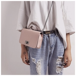 Detail of pink PU leather square bag with silver twist lock and black metal chain