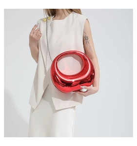 Détail du sac à main sphérique rouge métallique avec chaîne argentée et poignée ronde