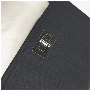 Detail of black Saffiano leather texture with rectangular silver metal twist lock closure