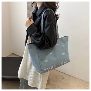 Détail du sac cabas en toile bleu clair avec broderie de lettres de mode blanches