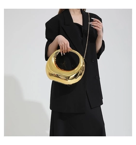 Détail du sac croissant doré brillant avec fini métallique et bandoulière chaîne