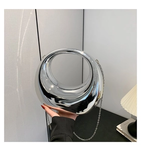 Gros plan d'un sac à main argenté en forme de croissant avec finition miroir et chaîne chic