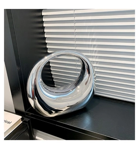 Gros plan d'une sculpture d'anneau creux argenté moderne avec finition miroir réfléchissante