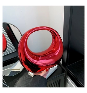 Détail du sac à main rouge circulaire au fini métallique brillant et bandoulière en chaîne