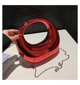 Vue détaillée d'un sac à main rouge métallisé avec poignée ovale et chaîne argentée