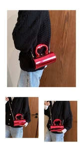 Red cylindrical acrylic clutch bag with heart handle and metal chain strap details
