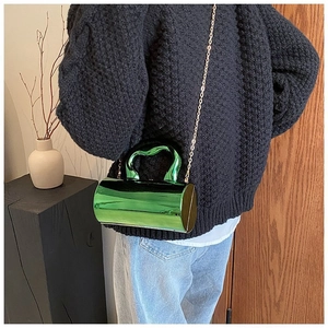 Metallic green cylindrical box bag with heart handle and gold chain on model