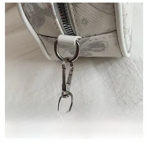 Detailed close-up of the detachable silver metal hook on a white butterfly Boston bag